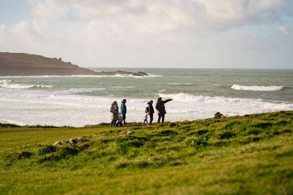 A family walking across the Island in St Ives, one of Cornwall's most famous towns, a great rainy day idea for families in Cornwall.