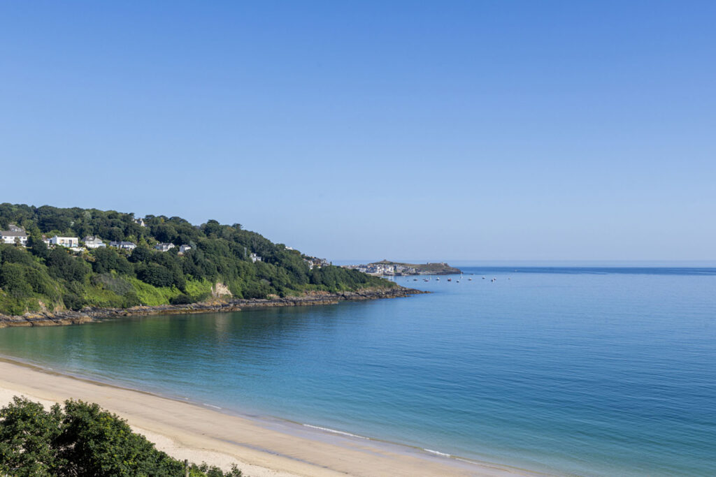 A clear blue sky over Carbis Bay, highlighting the beauty of one of Cornwall's best towns and villages to visit.
