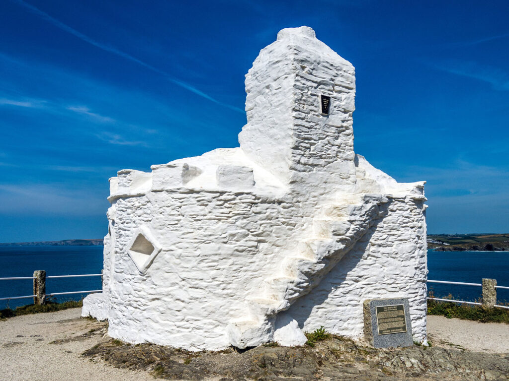 A white stone building, Huer's Hut, with a ladder on top, set in a scenic area of Newquay, a great thing to do off the beaten track.
