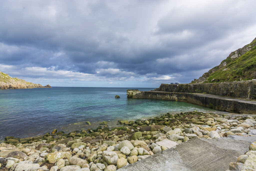Scenic Lamorna Cove features a rocky shoreline and calm waters, inspiring writer John le Carre's thrilling narratives.