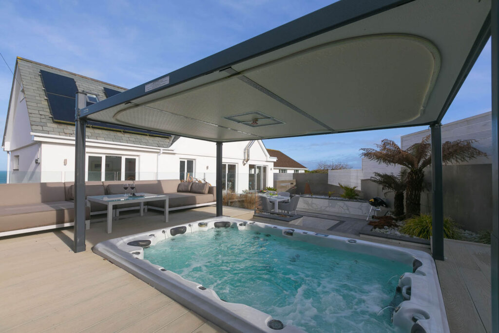 A cosy hot tub on a deck with a roof at Solstice, a new Cornish Escapes Holiday Cottage.