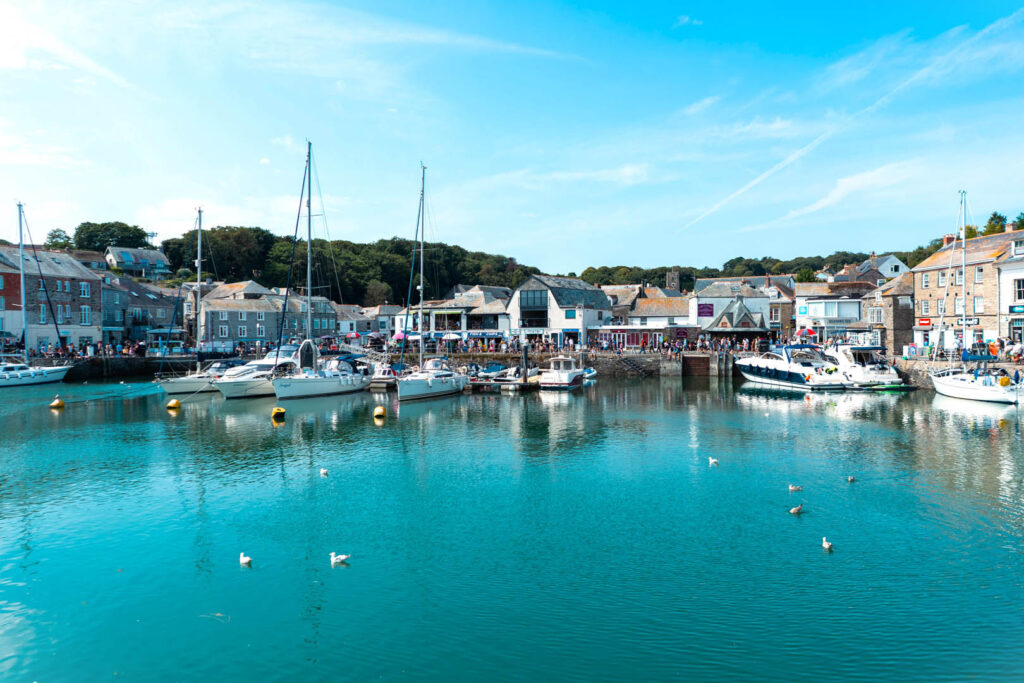 Serene view of Padstow Harbour, showcasing calm waters reflecting the sky and surrounding boats, the base for this guide on locals tips and secrets in Padstow.