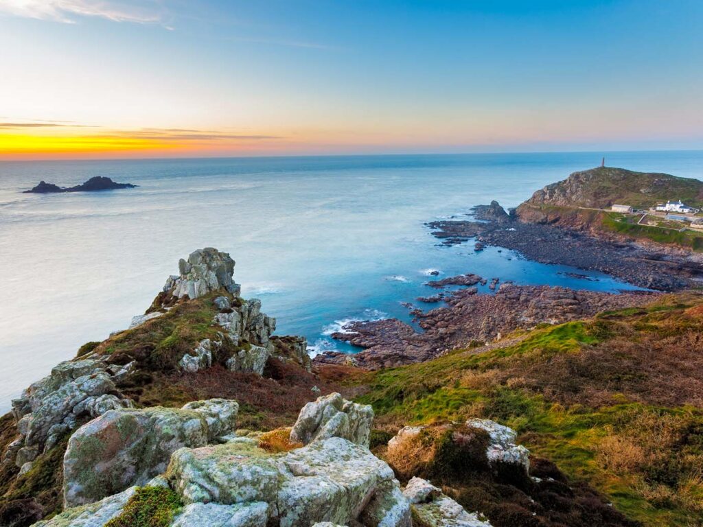 A stunning sunset casts vibrant colors over the coast near Cape Cornwall, illuminating the sky and sea, a great place to visit from a St Just and Pendeen holiday cottage.