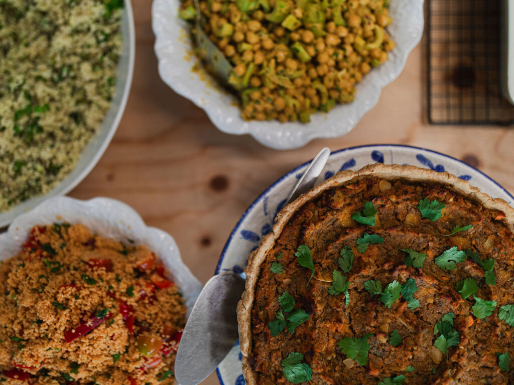A table filled with colorful bowls of various dishes, showcasing a delightful spread from Yvette's Pantry at Carbis Bay, an unmissable place for food and drink in Carbis Bay.