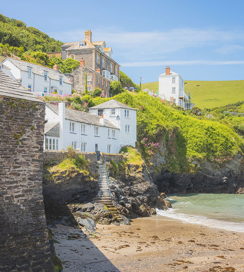 Scenic view of Port Isaac beach with charming houses perched on a hillside, showcasing coastal beauty and tranquility, a great thing to do in Port Isaac.