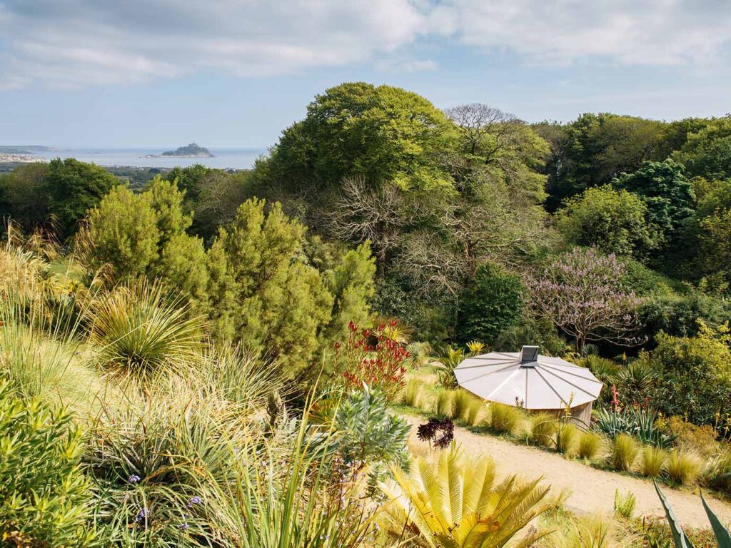 Lush Tremenheere Sculpture Gardens featuring diverse sculptures amidst vibrant greenery, a great piece of Mount's Bay arts and heritage.