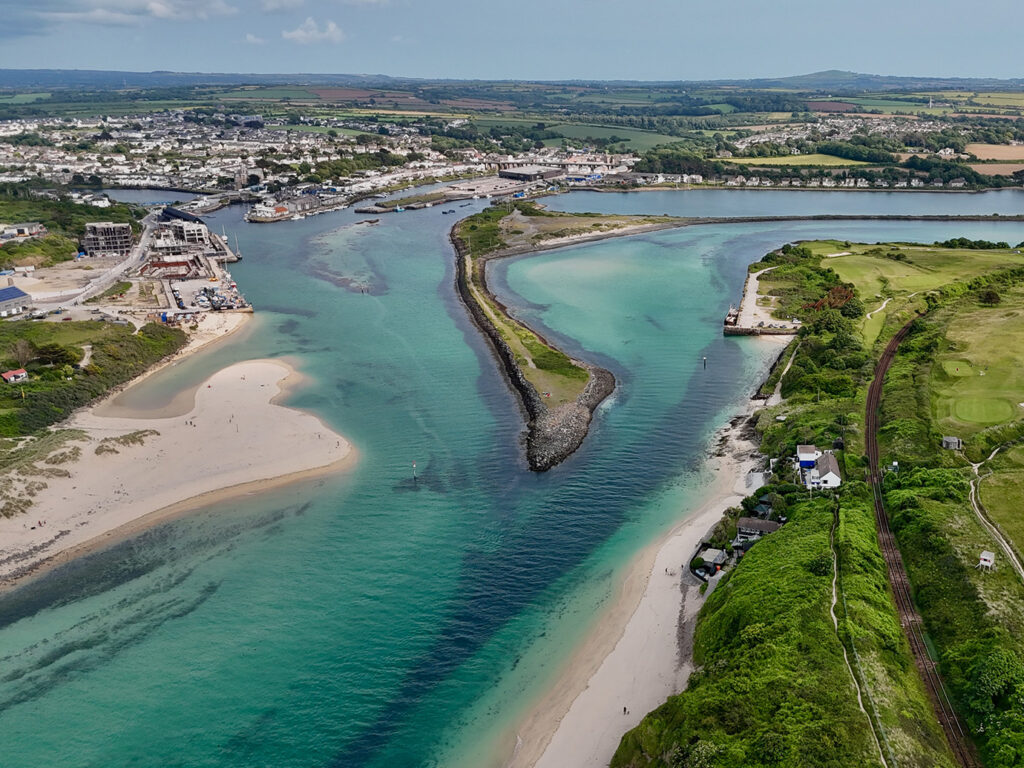 Aerial view of Hayle, showcasing the beach, estuary, and town, highlighting the scenic coastal landscape and the many places for food and drink in Hayle.