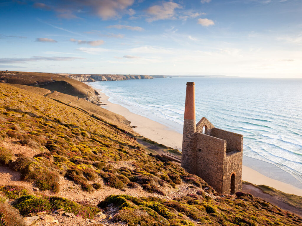 Scenic view of a beach with the ruins of Towanroath Engine House perched on a hillside near St Agnes.Scenic view of a beach with the ruins of Townaroath Engine House perched on a hillside near St Agnes, explore food and drink options nearby.