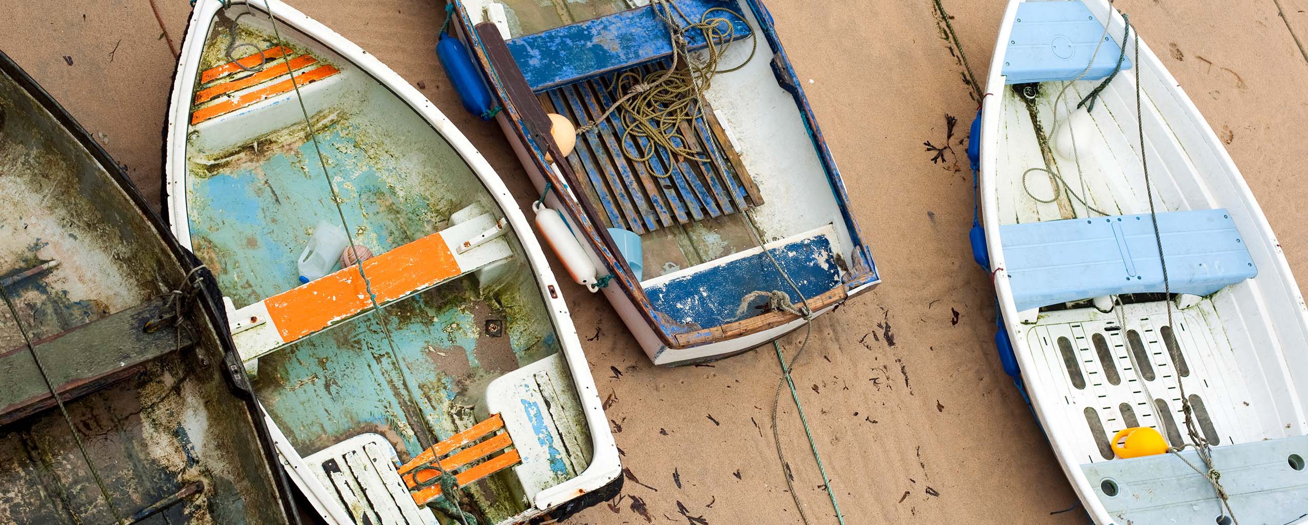 Vibrant boats lined up in St Ives Harbour, reflecting the charm of the coastal town, fishing is key to St Ives' arts and heritage.