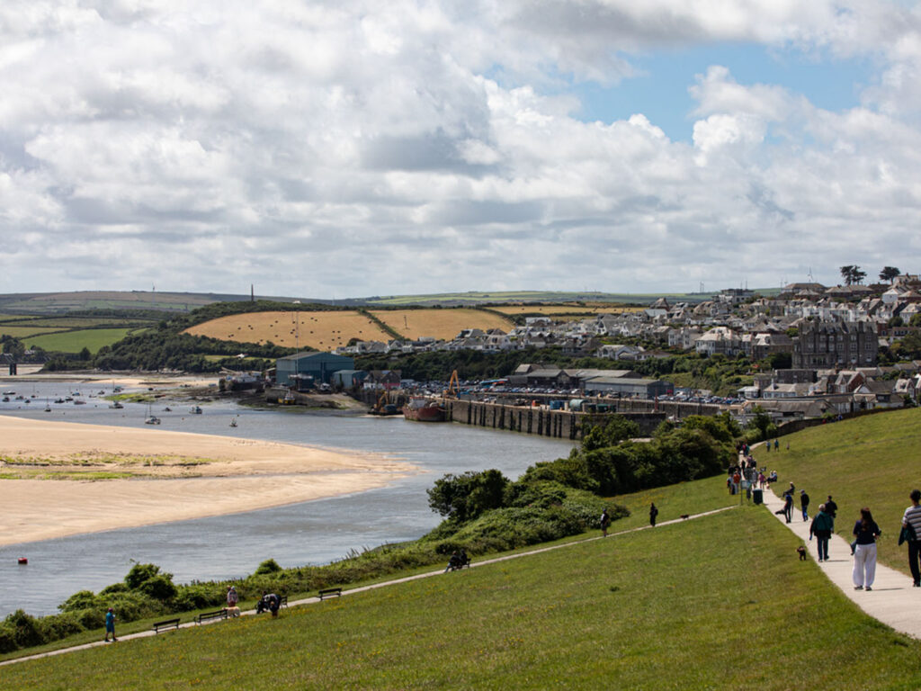 A serene view of a large body of water in Padstow, reflecting the sky and surrounding landscape, a part of Padstow's arts and heritage.