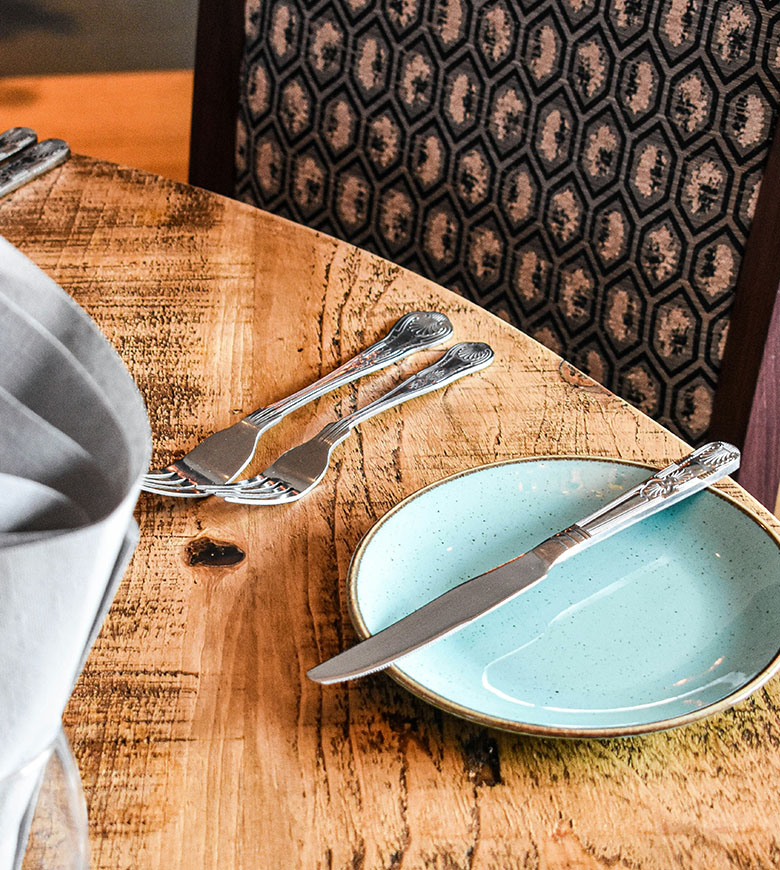 A table set with a plate and a neatly folded napkin, inviting guests to discover food and drink in Port Isaac.
