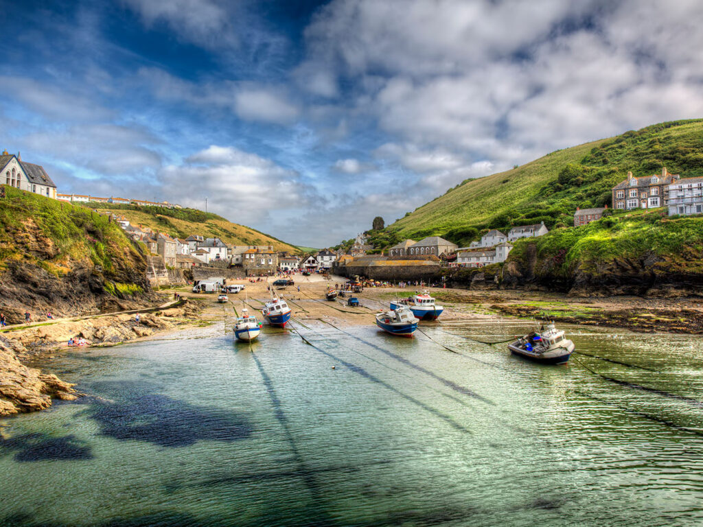 Port Isaac Harbour showcases a cluster of boats with a picturesque hill rising behind them, capturing the coastal charm.